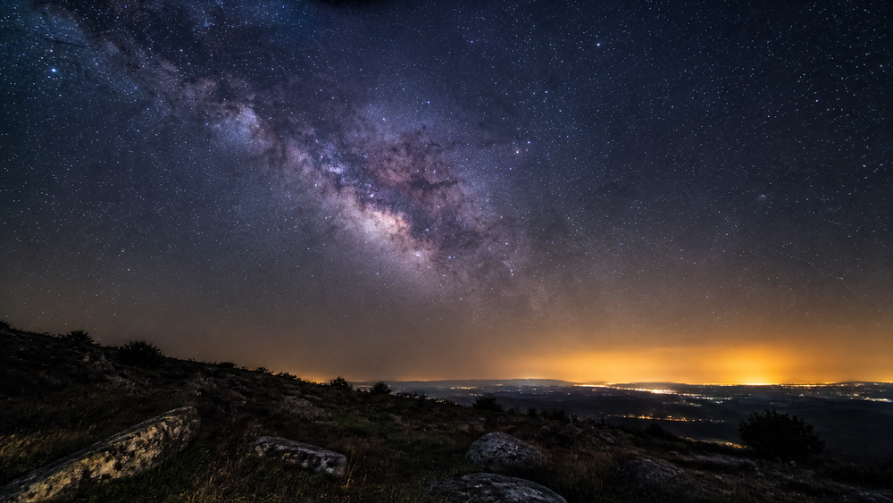 Milky Way above a rural hill with distant light pollution